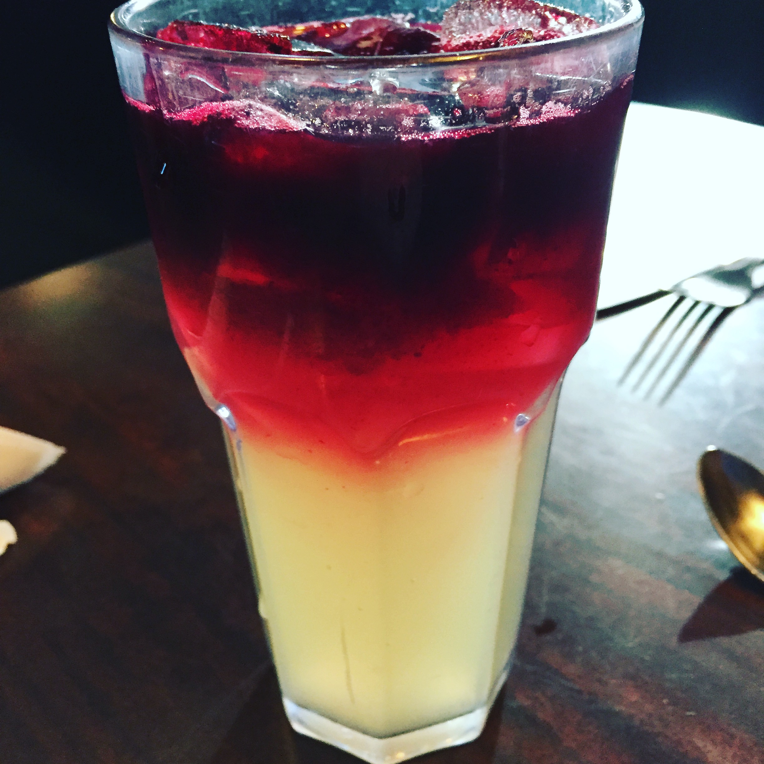 a glass of liquid with a red and white liquid in it