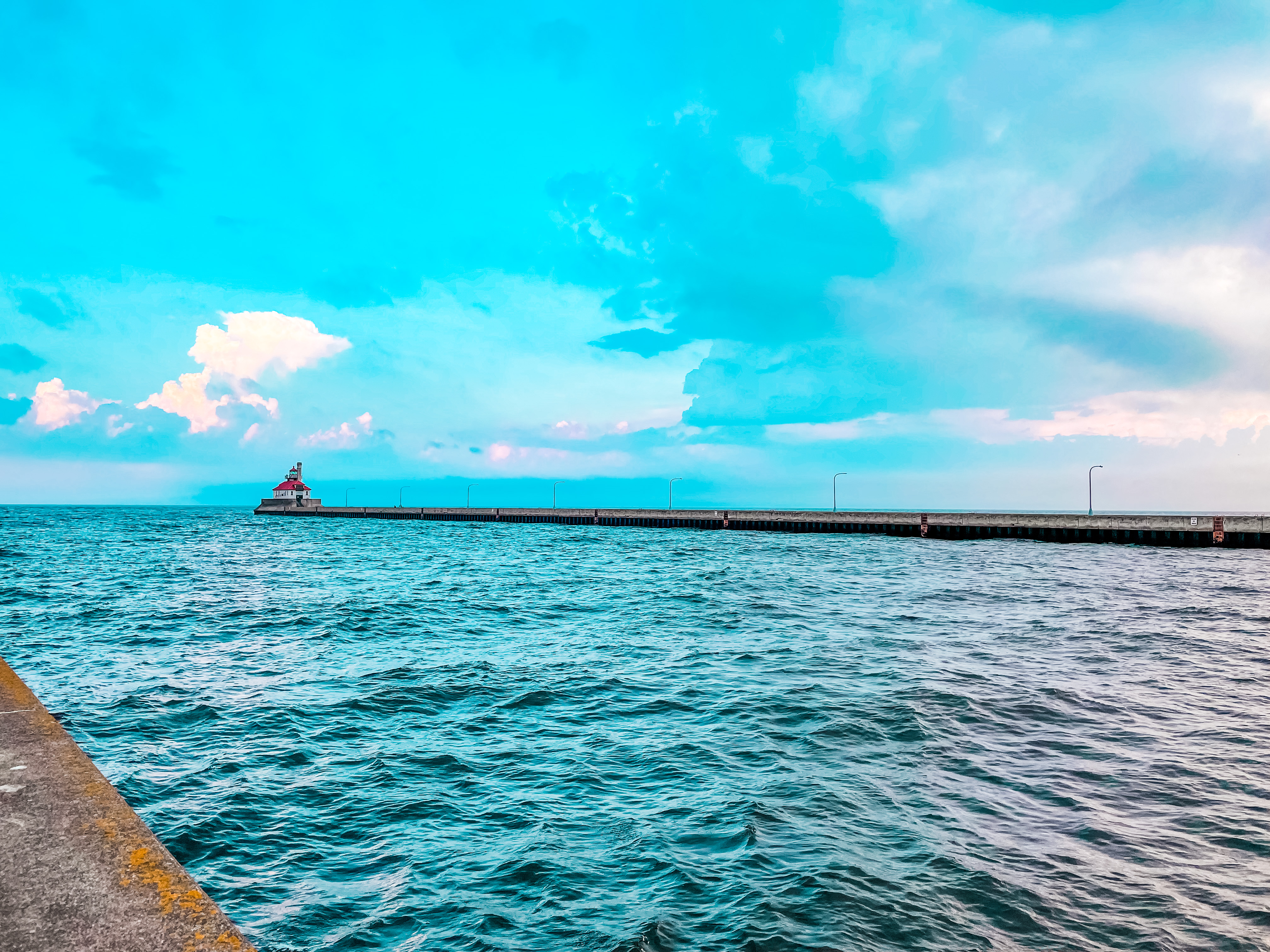 a body of water with a pier and a lighthouse