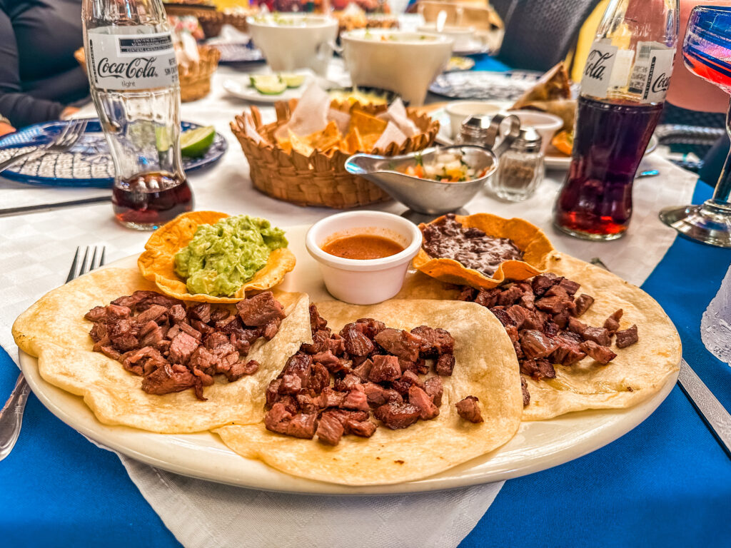 a plate of tacos with guacamole and sauce