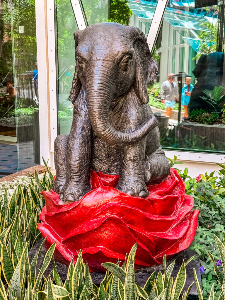 a statue of an elephant sitting on a red rose on Utopia of the Seas